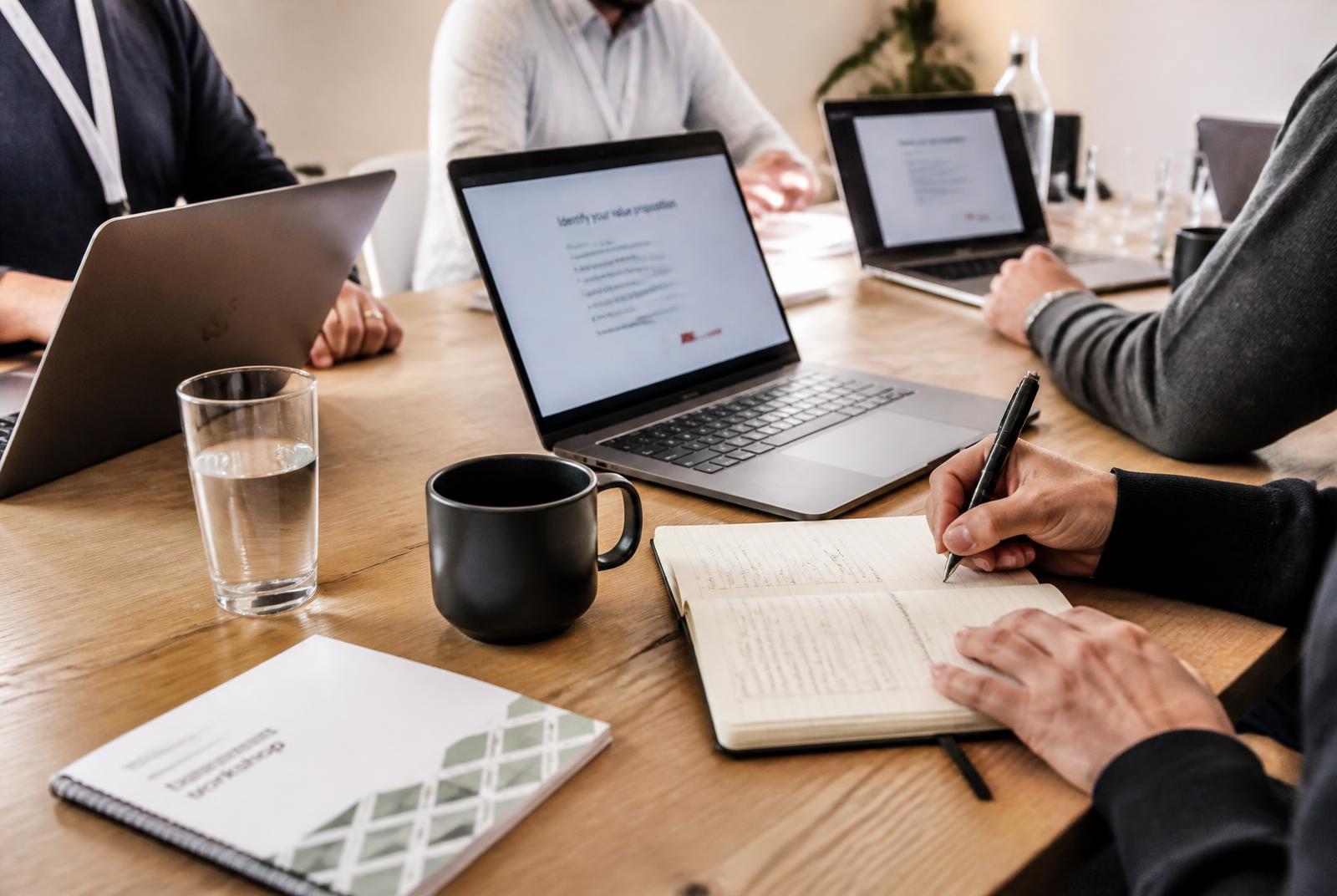 Deelnemers werken tijdens een AI-training met laptops aan eigen voorbeelden — definitieve fotografie volgt